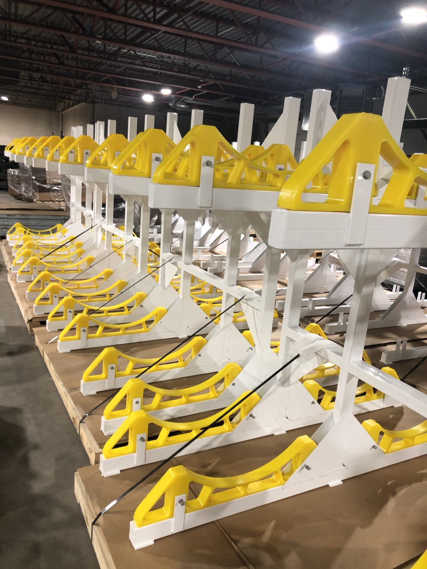Rows of fabricated fixtures staged on pallets in the warehouse
